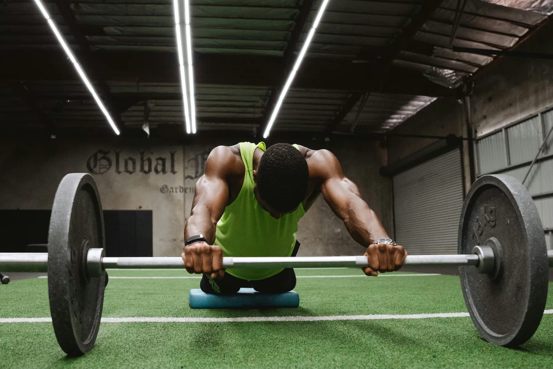 Athlete resting over a loaded barbell in a gym